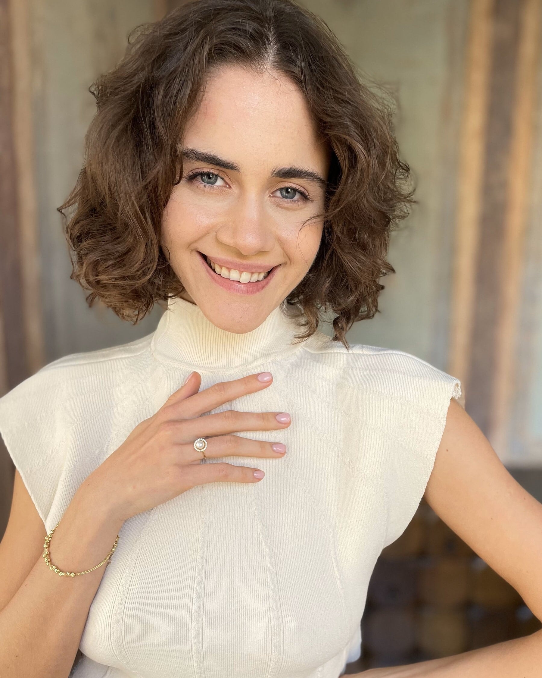 Woman wearing a white sleeveless top with a blurred background