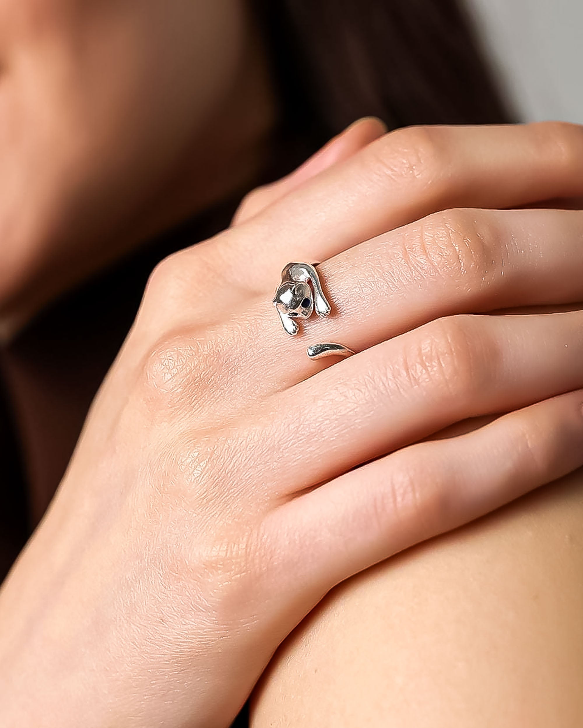 Silver elephant ring on a person's finger with a neutral background