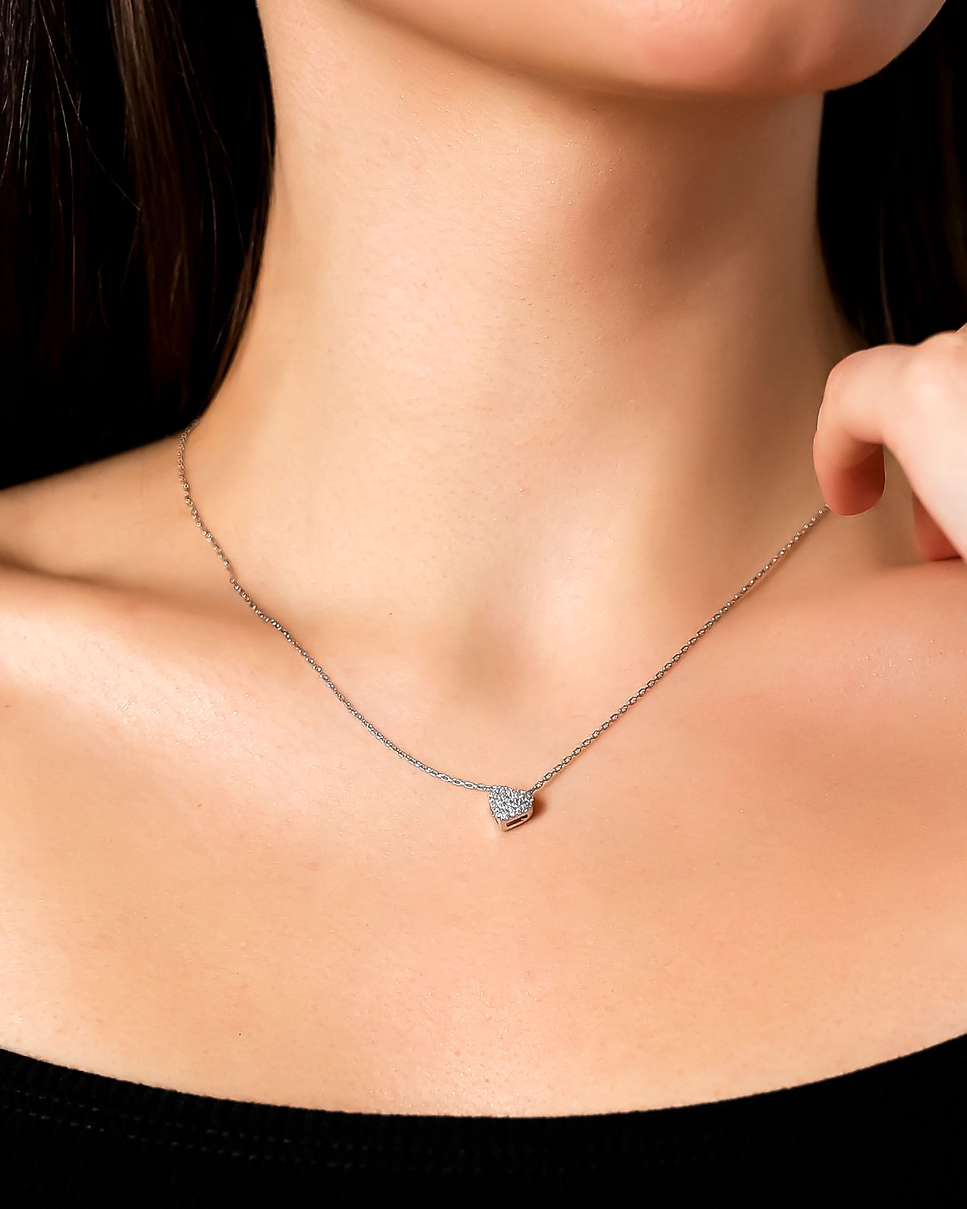 Necklace with a heart-shaped pendant worn by a person