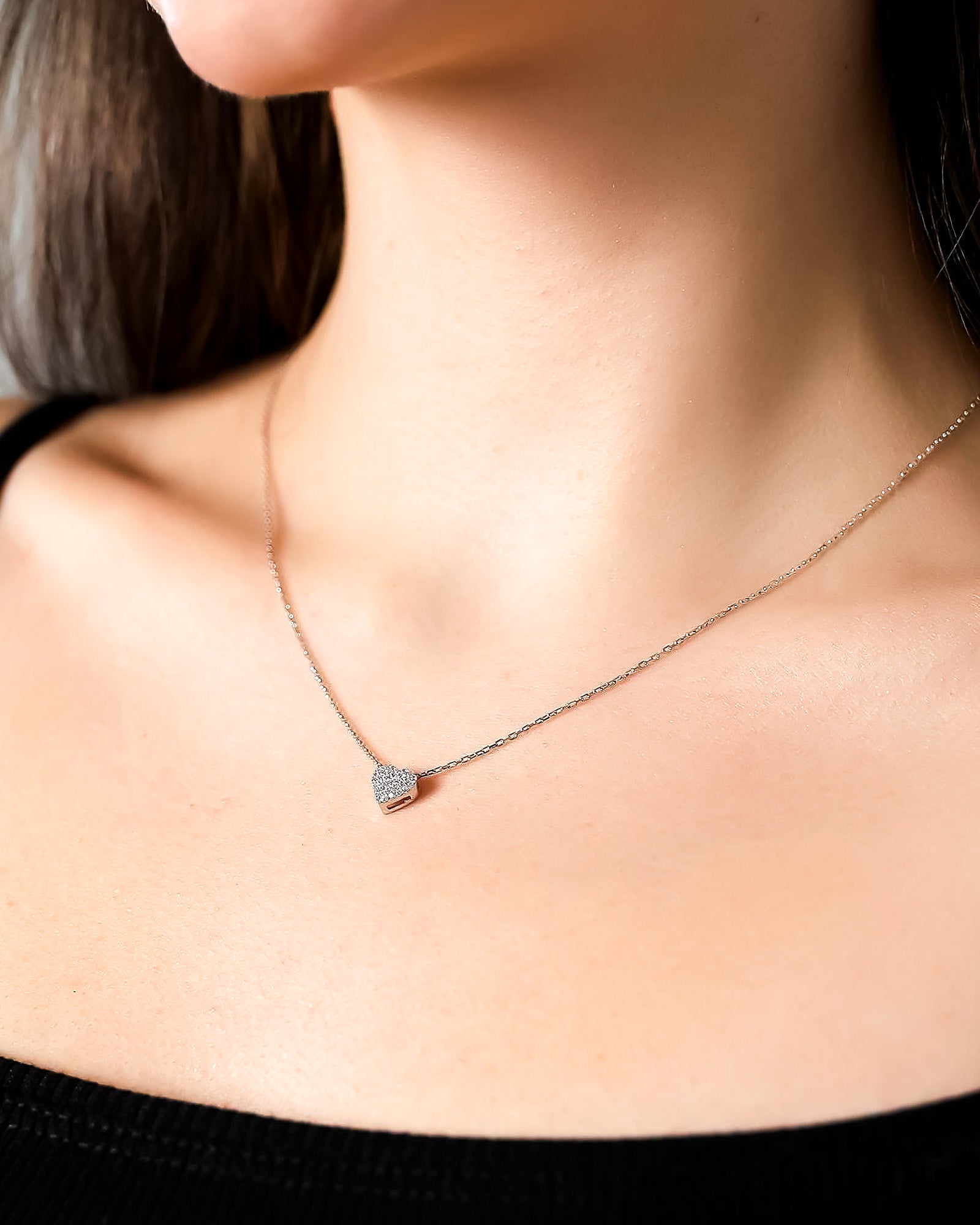 Necklace with a heart-shaped pendant worn by a person