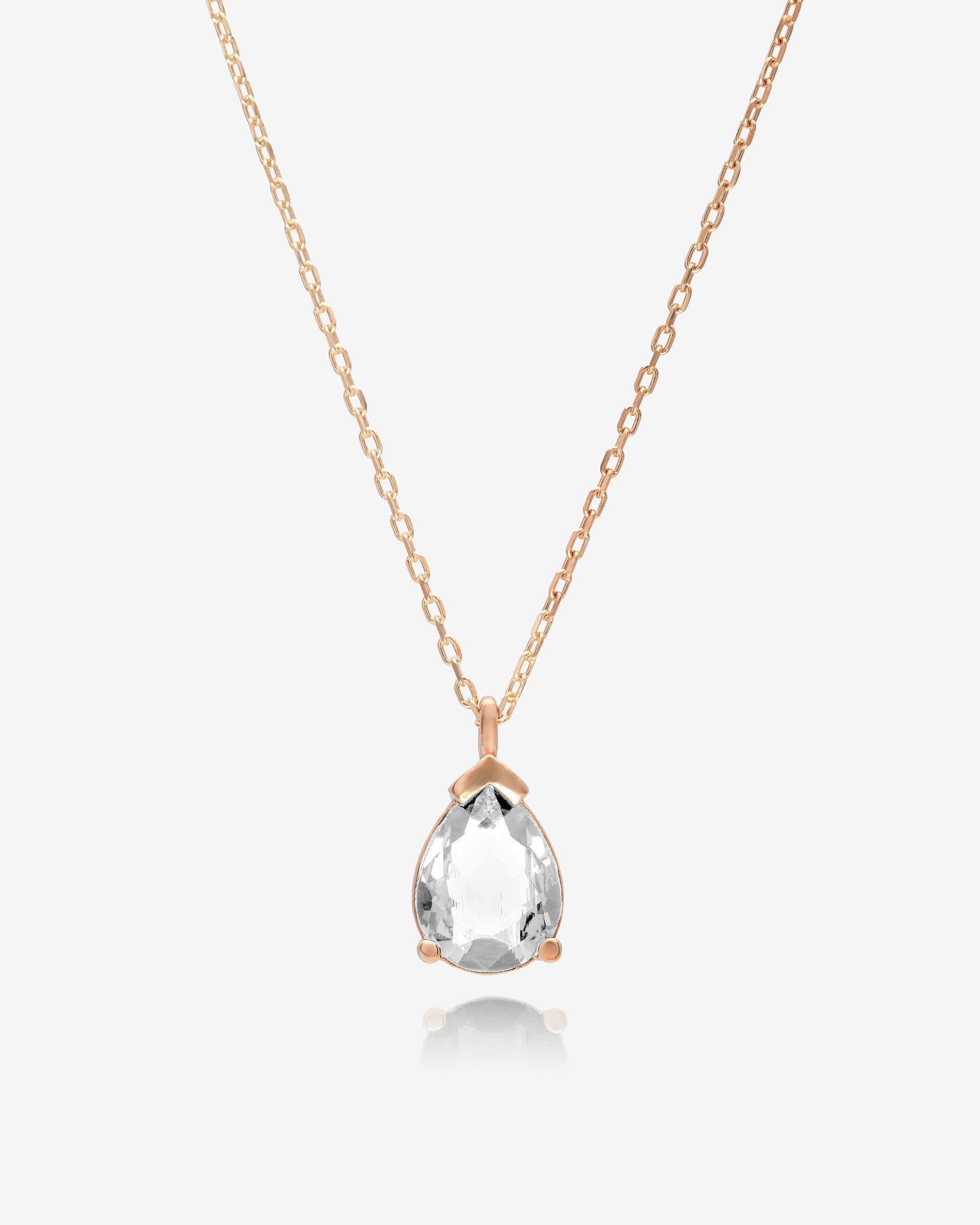 Rose gold necklace with a clear teardrop pendant on a white background