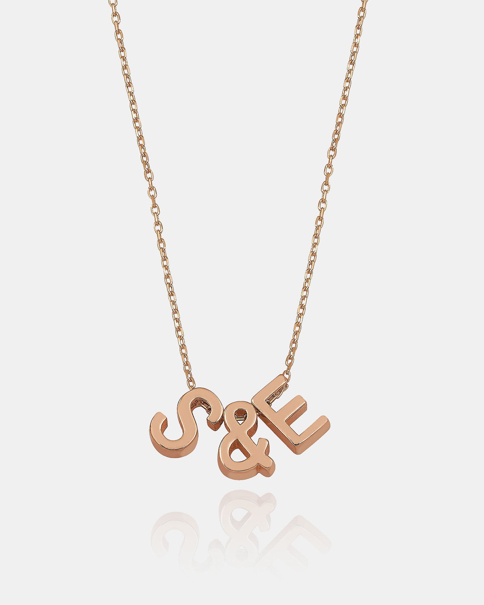 Rose gold necklace with 'S&E' letters on a white background